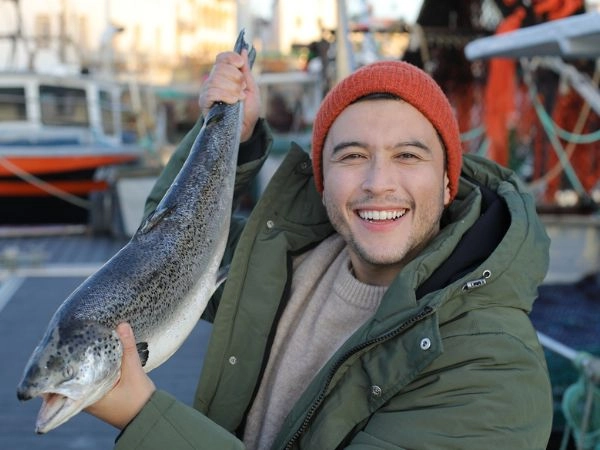 Pescatore che mostra un salmone
