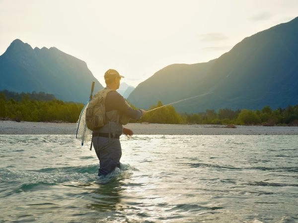 L’uomo pesca a mosca nel fiume L'uomo pesca a mosca nel fiume